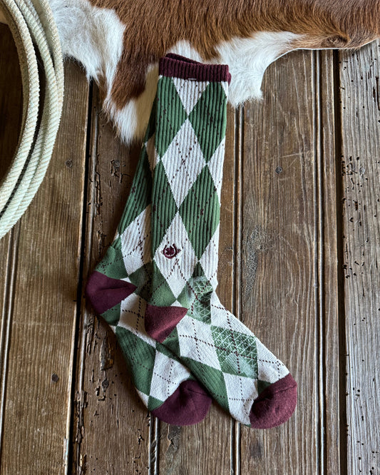 Plaid socks on a wooden surface with a cowhide in the background