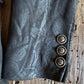 black fabric with decorative buttons on a wooden surface