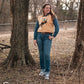 Model standing in trees, dressed in a stylish modern western outfit.