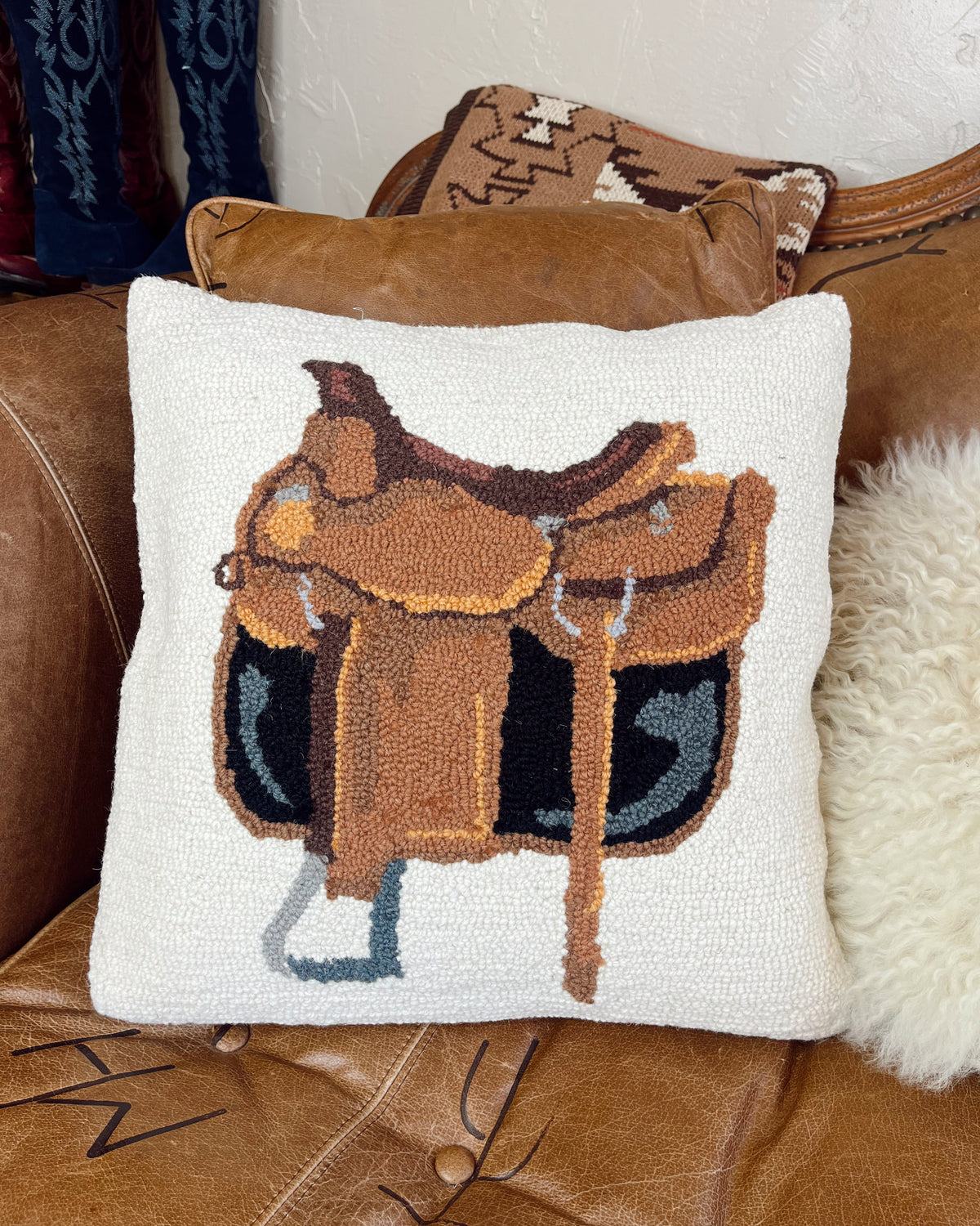 Decorative pillow with a saddle design on a brown leather surface