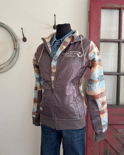 Jacket with patterned sleeves on a mannequin against a rustic background