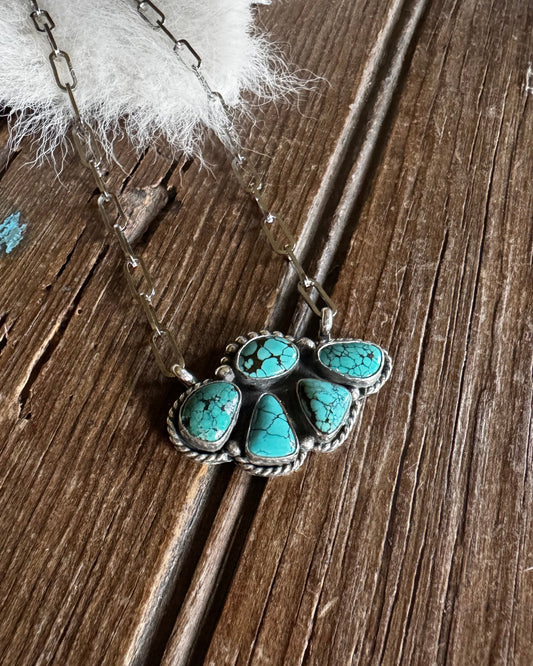 Turquoise stone necklace on a wooden surface