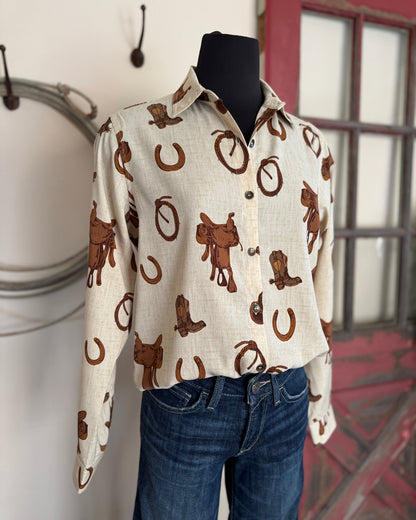 Mannequin wearing a white shirt with brown cowboy pattern and blue jeans against a neutral background