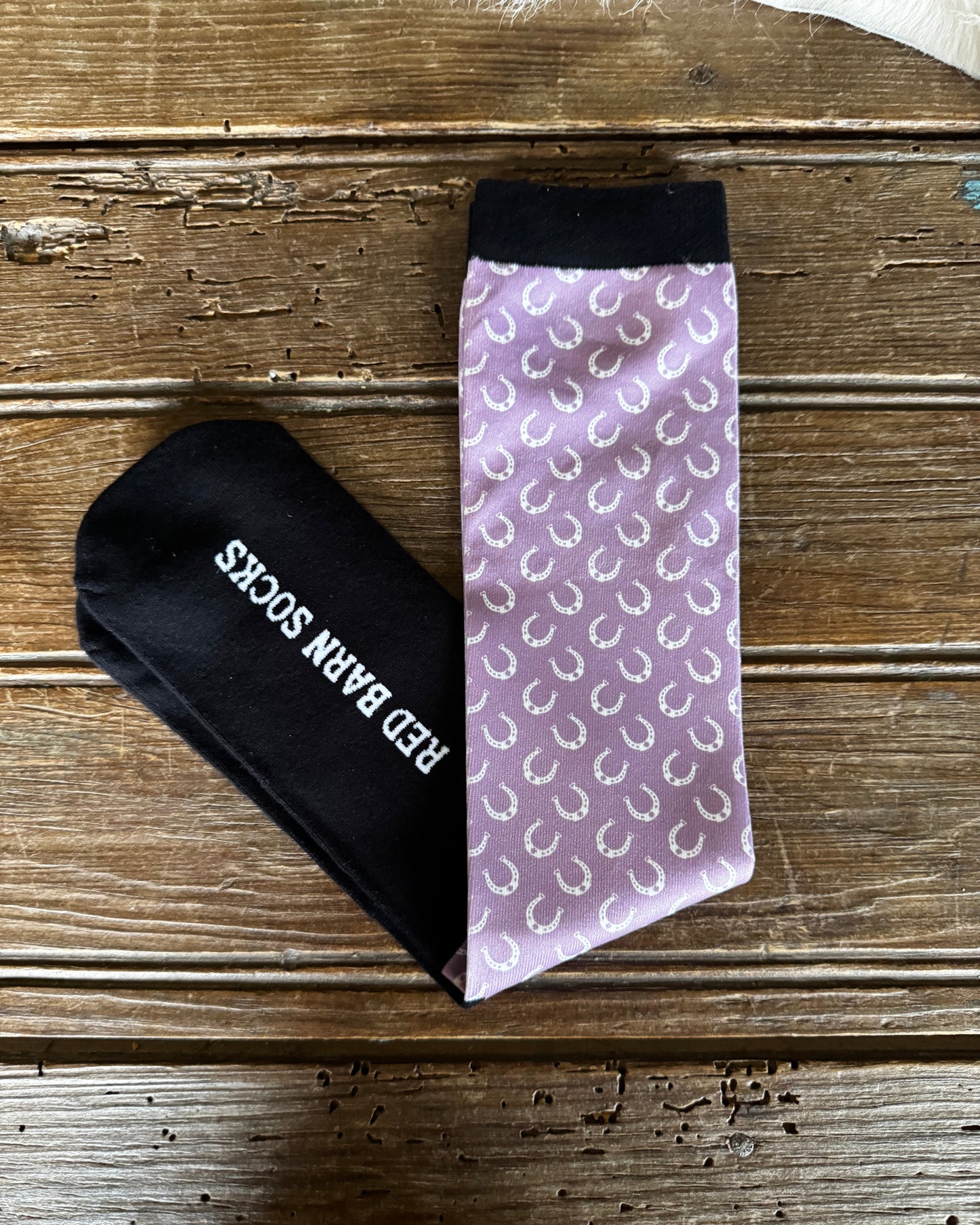 Black and purple patterned socks on a wooden surface