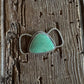 Turquoise teardrop twilly pendant with silver setting on a wooden surface