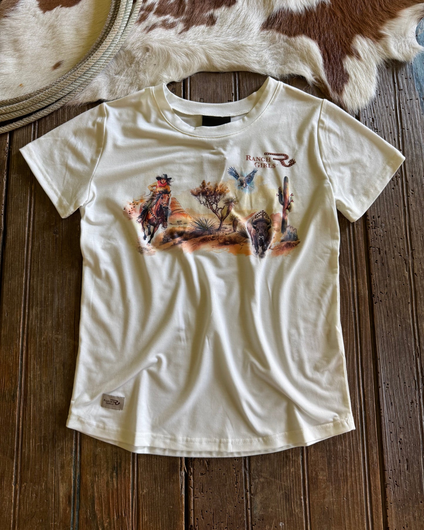 White t-shirt with graphic design on a wooden surface