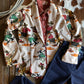 Colorful patterned jacket and blue jeans on a wooden surface with a cowhide rug in the background.
