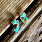 stud earrings with double turquoise stones on a wooden background 