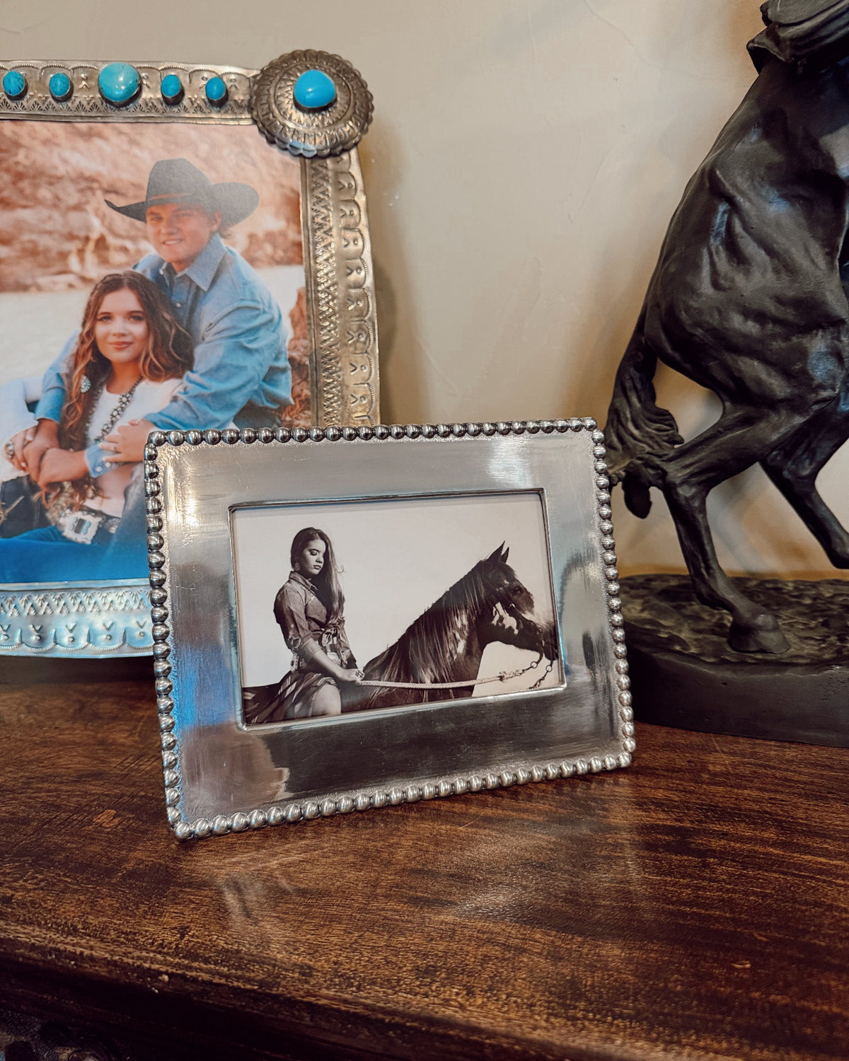 Decorative photo frames on a wooden surface with a horse and rider image.