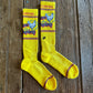 Cactus Alley Chicken Roping Performance Socks in yellow on rustic wood background 