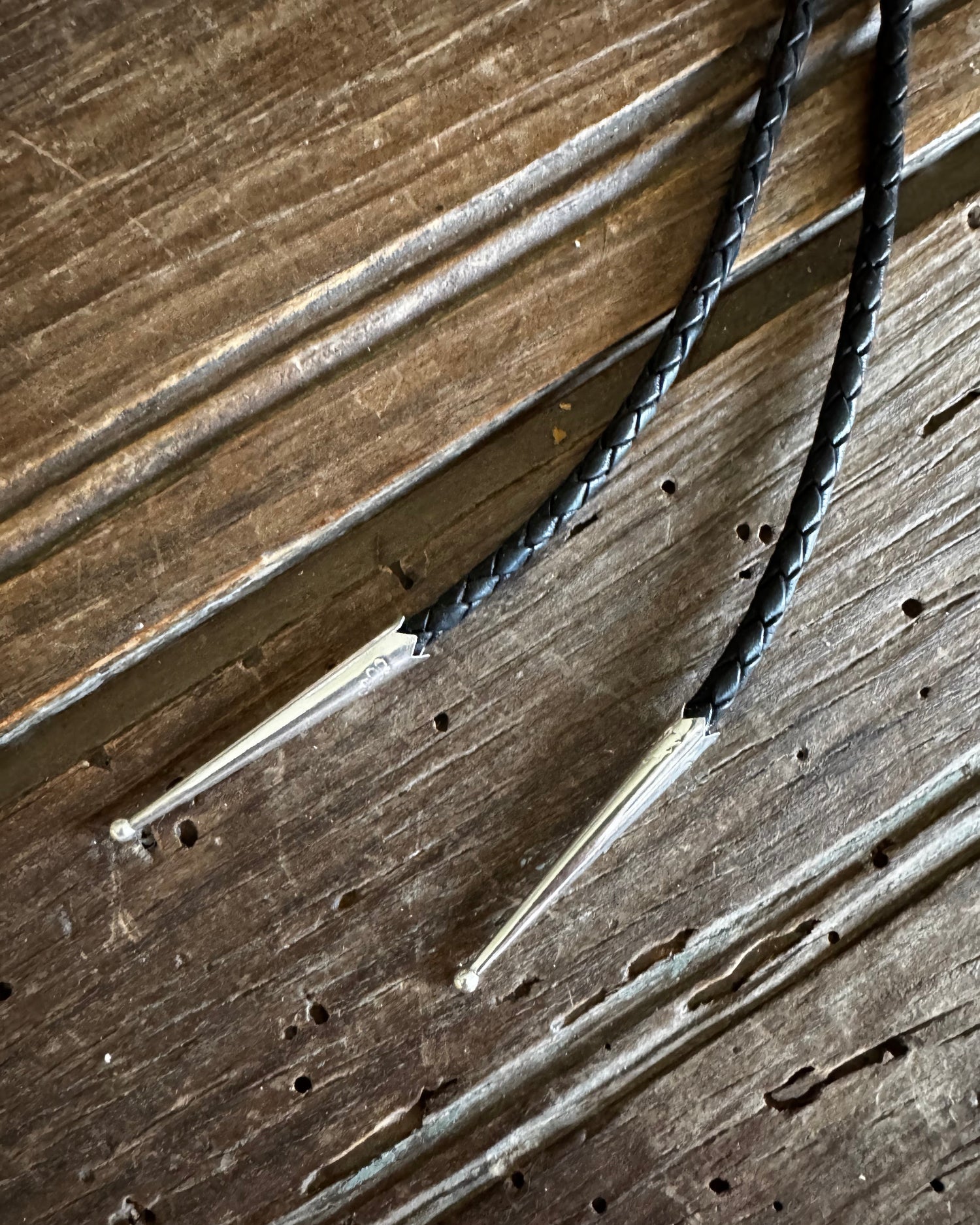 Two metal tools with black braided handles on a wooden surface