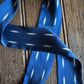 Blue ribbon scarf with white polka dots on a wooden surface