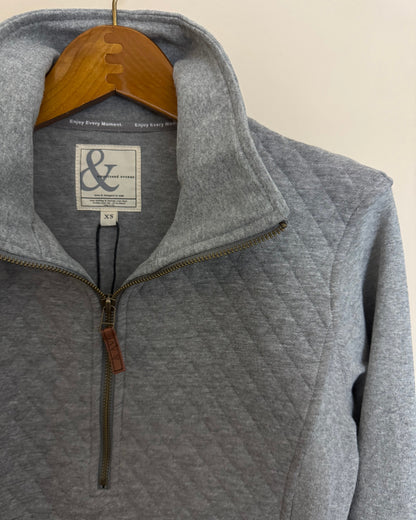 Gray pullover with a brand logo on a beige background