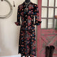 Floral dress on a mannequin with cowboy boots on a wooden floor.