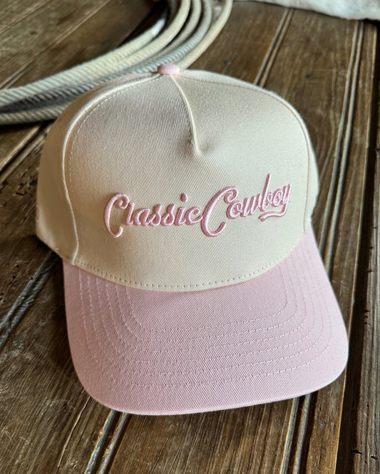 Pink and beige classic cowboy cap on a wooden surface
