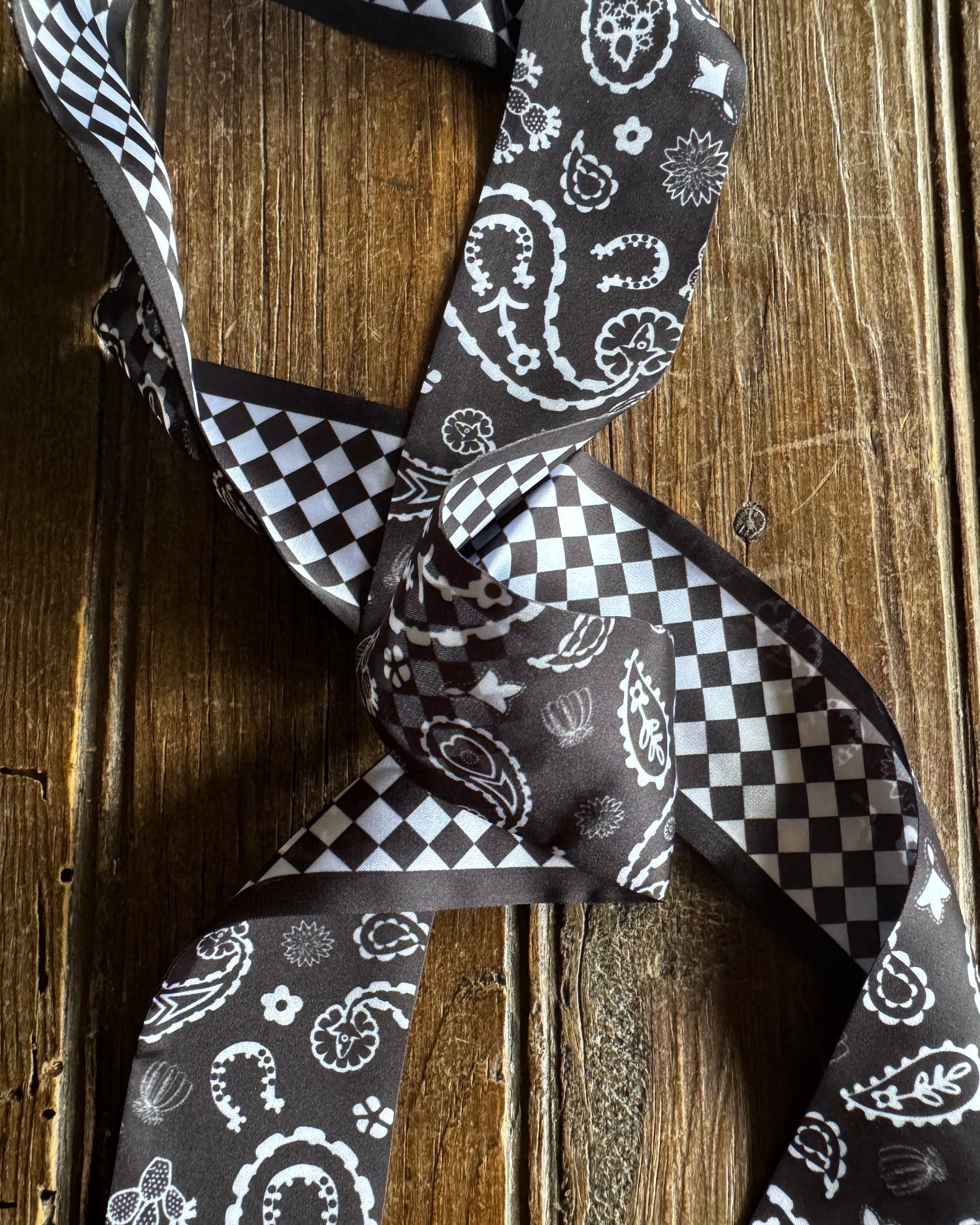 Black and white patterned tie on a wooden surface