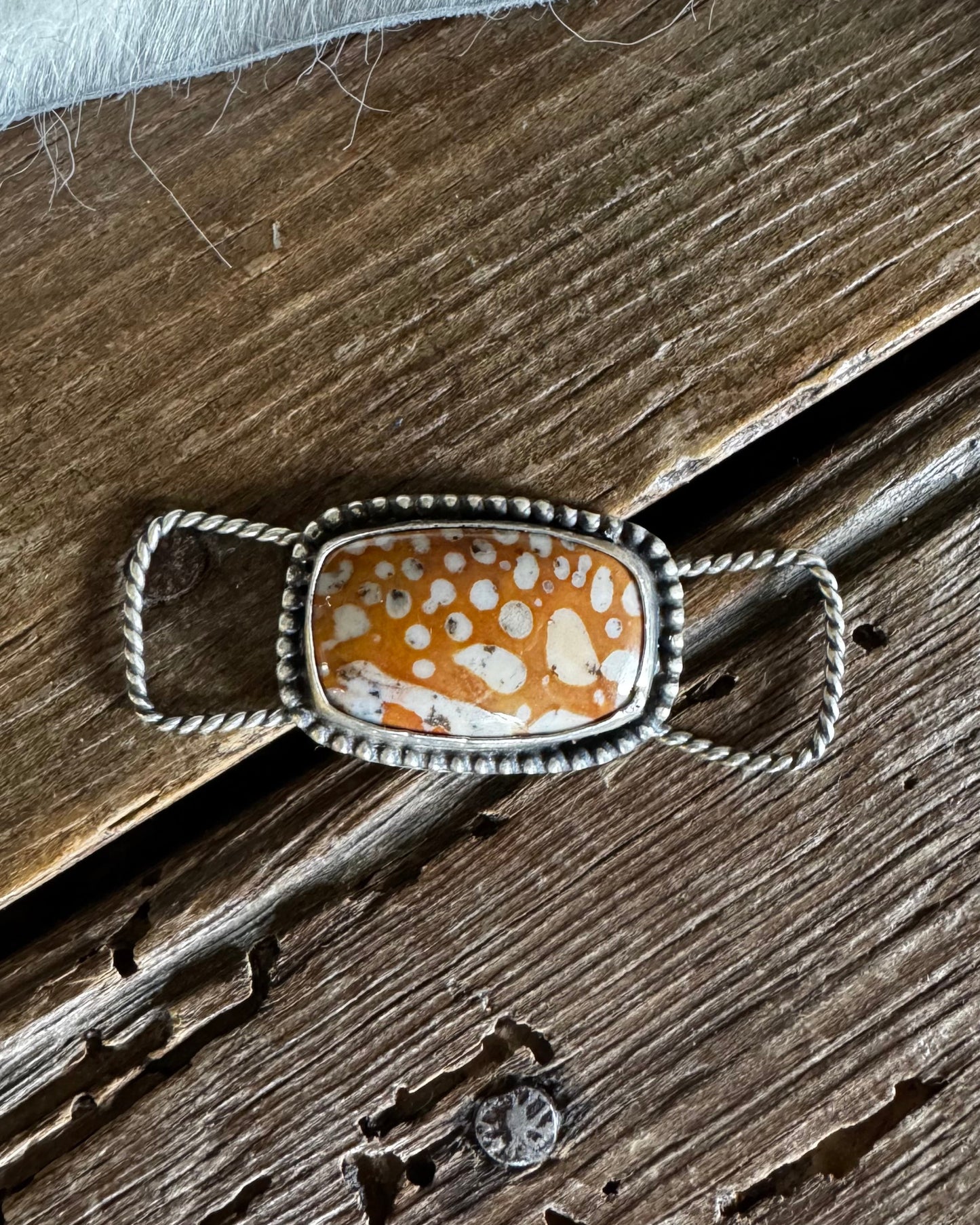 Decorative brooch with a floral pattern on a wooden surface