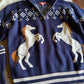 Navy blue sweater with horse design on a wooden surface