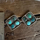 Turquoise stone brooch on a wooden surface with a ruler for scale