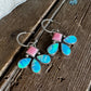 Flower-shaped earring with colorful stones on a wooden surface