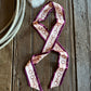 Snaffle bit ribbon scarf on a rustic wooden background with a rope