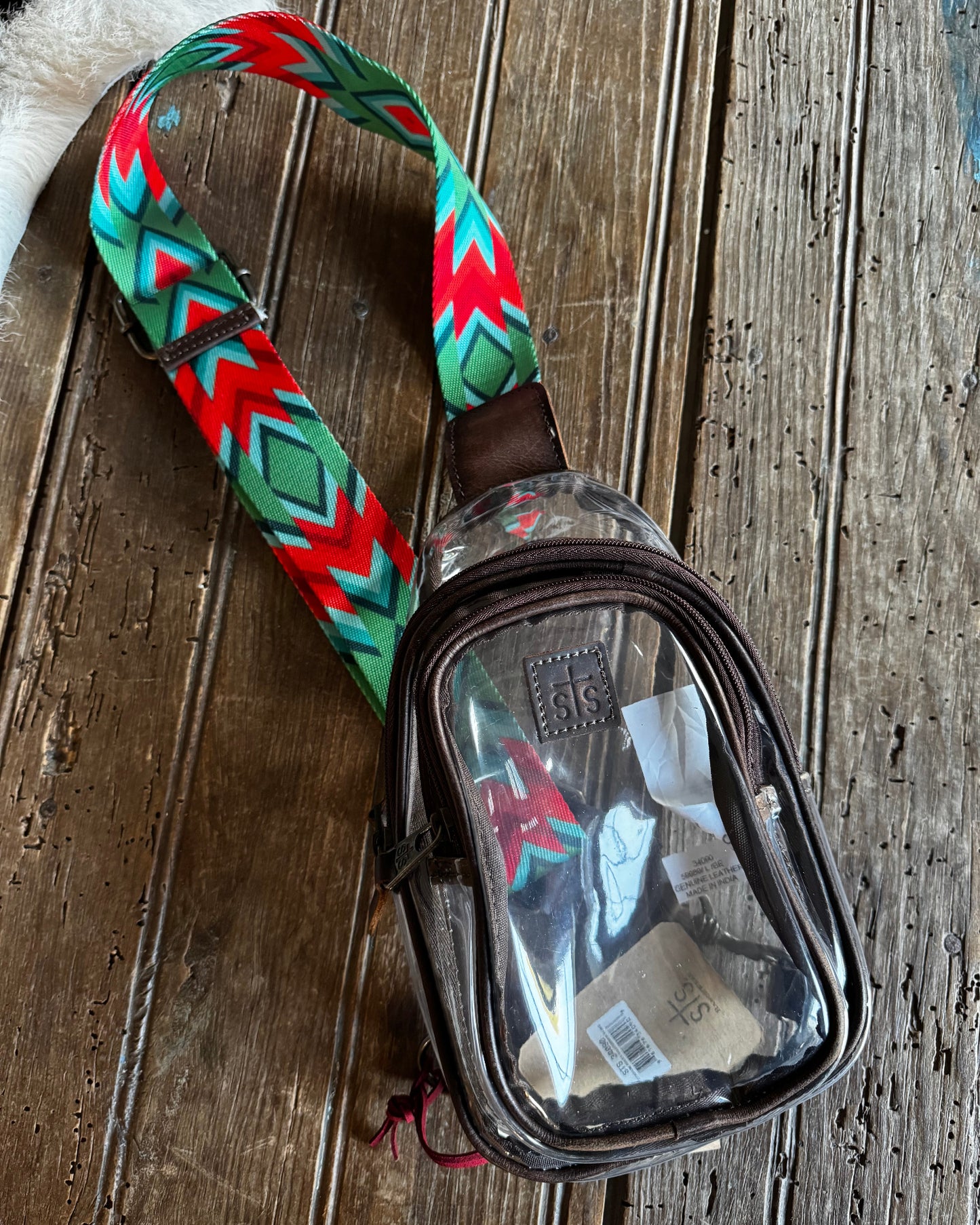 clear stadium bag with a bright aztec strap on a wooden background