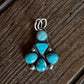 Turquoise stone and silver brooch on a wooden surface