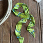 Green cactus patterned scarf on a wooden surface