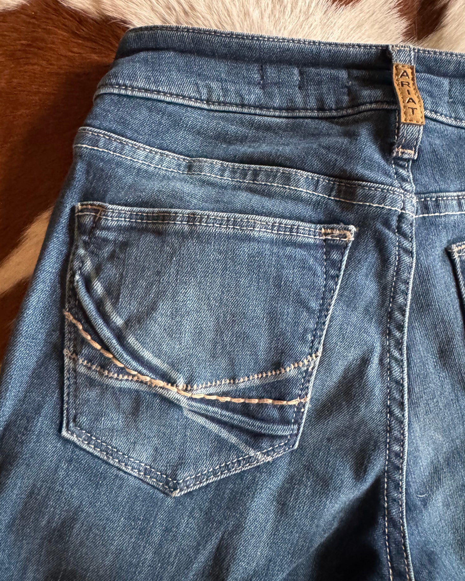 Close-up of blue denim jeans with a brand label on a textured surface