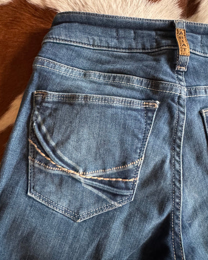 Close-up of blue denim jeans with a brand label on a textured surface