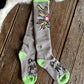 Gray socks with green accents and a colorful design on a wooden floor.
