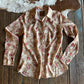Floral-patterned shirt on a wooden surface next to a cowhide rug