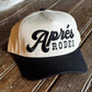 Cap with 'Apres Rodeo' branding on a wooden surface