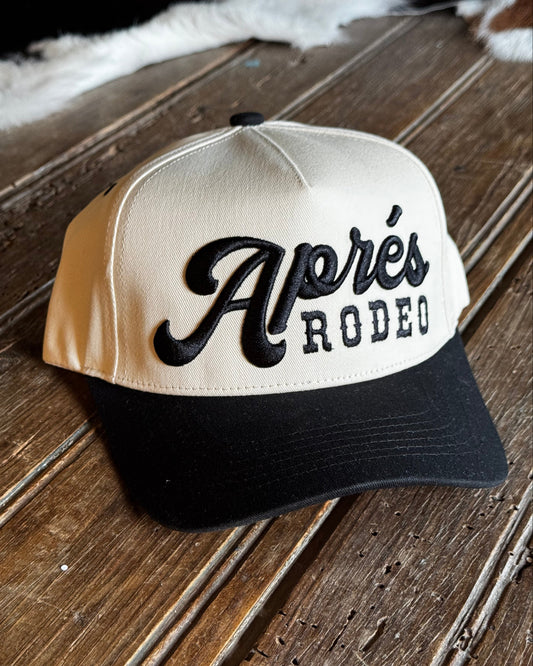 Cap with 'Apres Rodeo' branding on a wooden surface