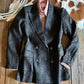 Dark jacket with button details on a wooden surface