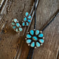Pair of turquoise stone earrings on a wooden surface