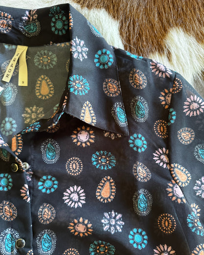 Close-up of a patterned fabric with decorative elements on a textured surface