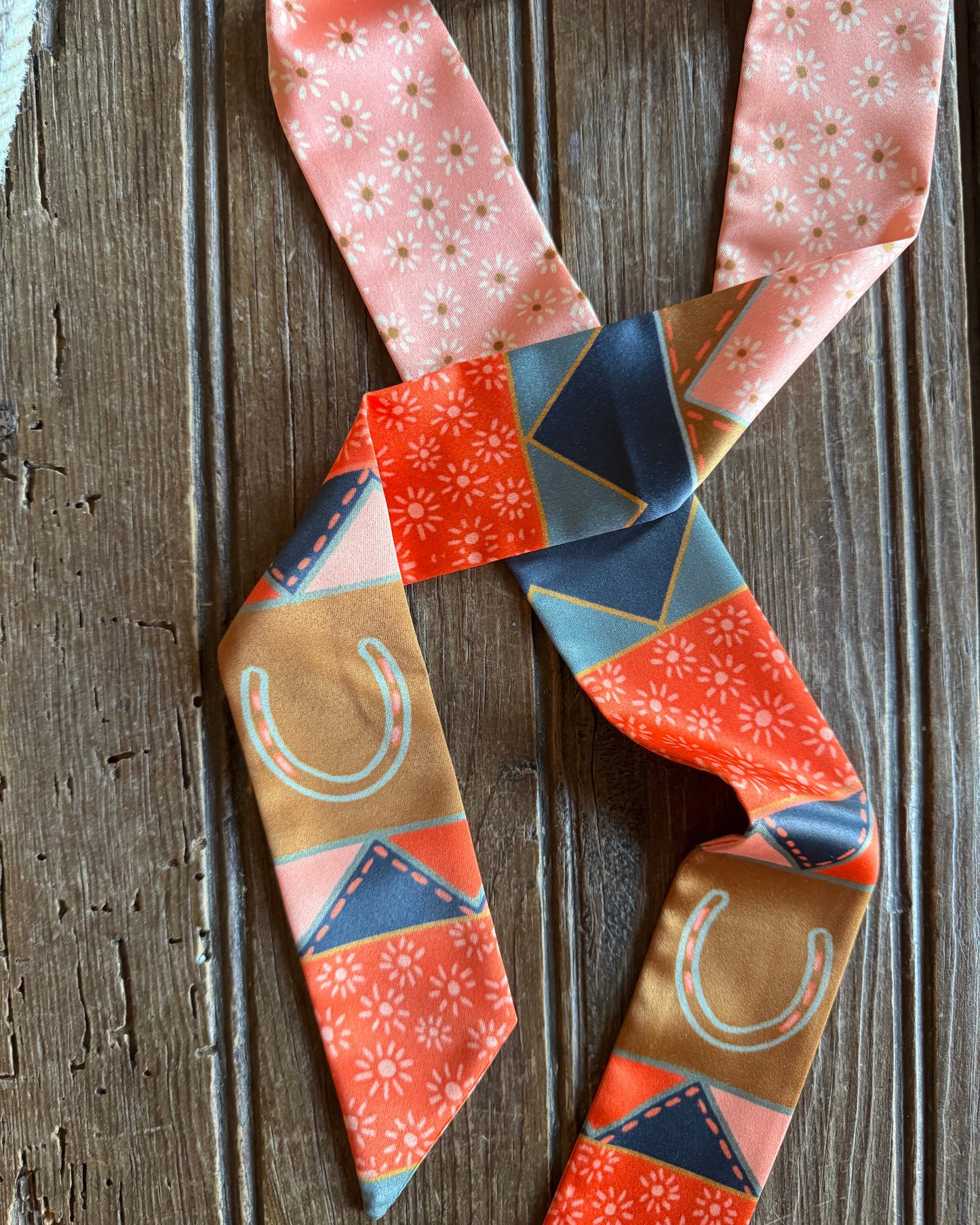 Close up of patchwork twilly scarf on a rustic wooden background