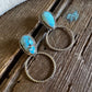 Turquoise stone earrings on a wooden surface