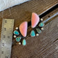 A pair of handmade drop earrings with large pink stone tops, smaller turquoise-blue stones, and silver-toned metal settings, displayed on a rustic wooden surface next to a metal ruler for scale.