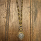 Gold necklace with a pendant on a wooden surface