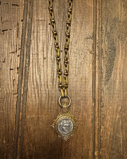 Gold necklace with a pendant on a wooden surface