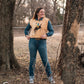 Model standing in trees, dressed in a stylish modern western outfit.