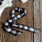Decorative belt with concho designs on a wooden surface