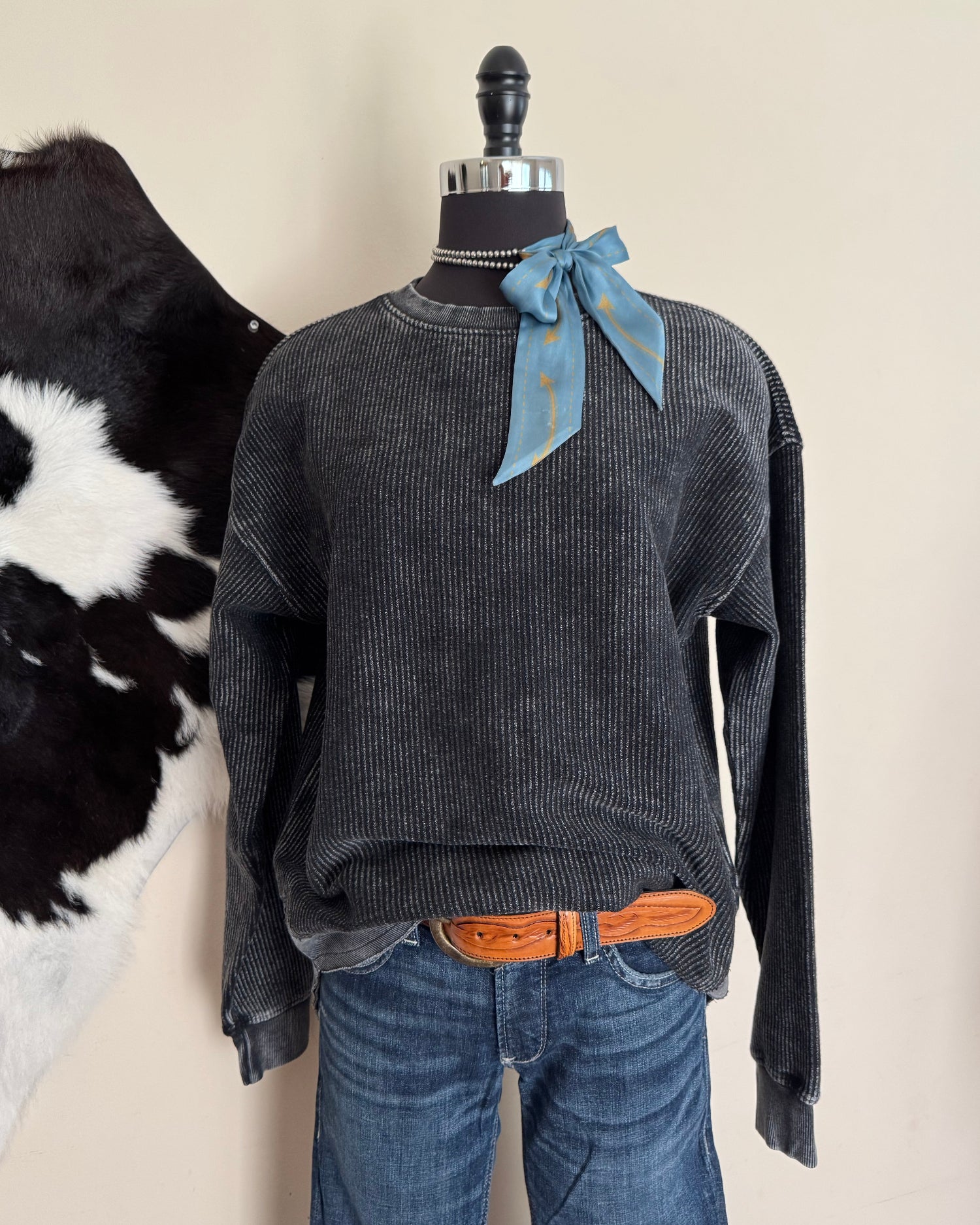 Gray shirt on a mannequin with a cowhide in the background