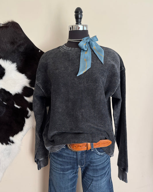 Gray shirt on a mannequin with a cowhide in the background