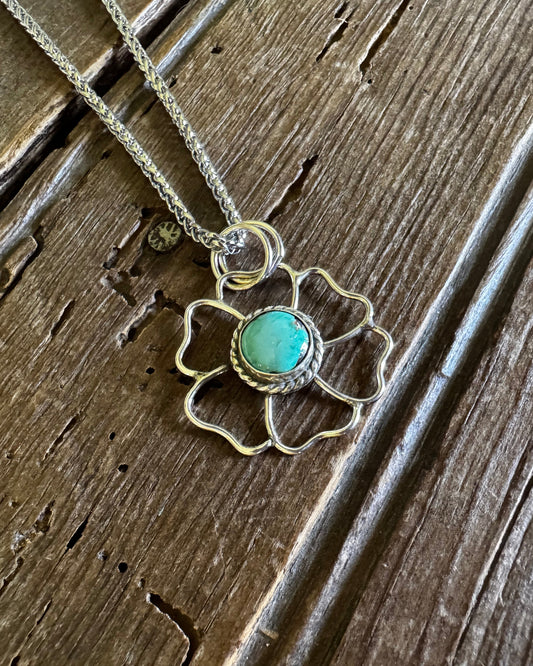 Necklace with a turquoise pendant on a wooden surface