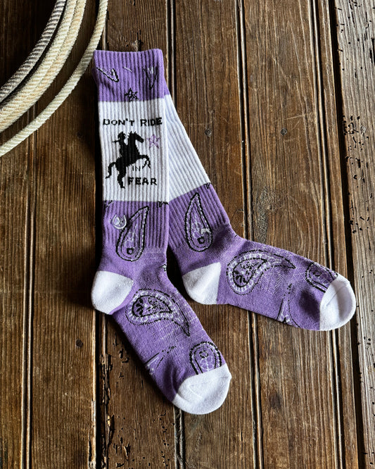 Purple and white socks with a brand logo on a wooden surface