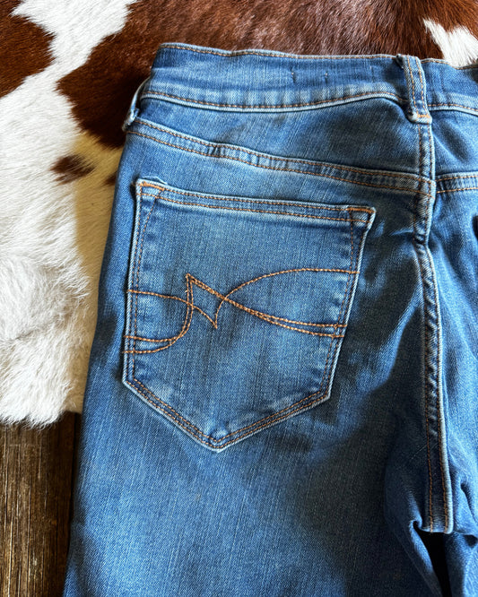 Blue jeans with a brand logo on the pocket against a cowhide rug background