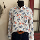 Floral-patterned shirt on a mannequin against a neutral wall.